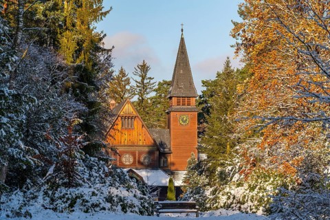 Wooden chapel in the style of Norwegian stave churches in the snow, south-west churchyard, historic
