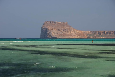 Lagoon, green sea, ship, tourist in the water, Venetian sea fortress Gramvoussa, peninsula