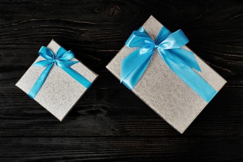 Gift birthday Christmas present concept, silver gift box with blue ribbon on dark wooden background