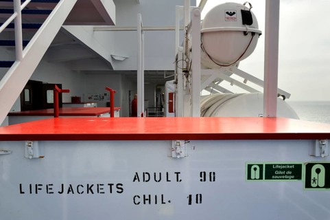 Box of life jackets and inflatable life rafts in hard-shell canisters on board a ferry boat