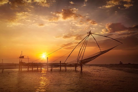 Kochi chinese fishnets on sunset. Fort Kochin, Kochi, Kerala, India. With light leak and lens flare