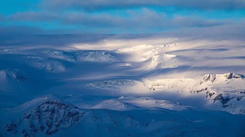 Light and shadow over the snowy hills and mountains of Myrdalsjökull, Sudurland, Iceland, Europe
