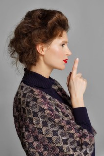 Portrait of a beautiful sexy fashion model pointing her finger up. Wedding make up and hair. Red