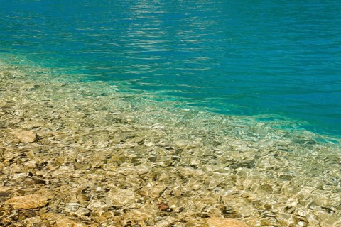 Fascinating play of colours and shapes of the clear water of Lake Walen at the edge of the shore,