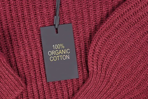 Label saying '100% organic coton' attached to environmental friendly produced pullover