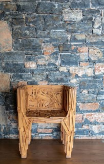 Designer chair in front of a stone wall, Crete, Greece, Europe