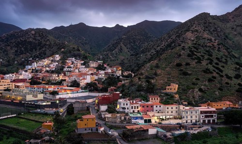 View of Vallehermoso and the surrounding mountain landscape in the evening under a cloudy sky.