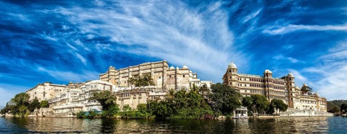India luxury tourism concept background, panorama of Udaipur City Palace from Lake Pichola.