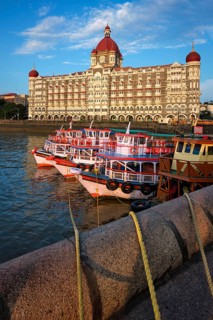 MUMBAI, INDIA, OCTOBER 31, 2019: Tourist boats in front of the famous Taj Hotel in the morning
