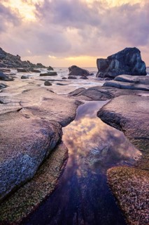 Rocks on beach of fjord of Norwegian sea in winteron sunset. Utakliev beach, Lofoten islands,