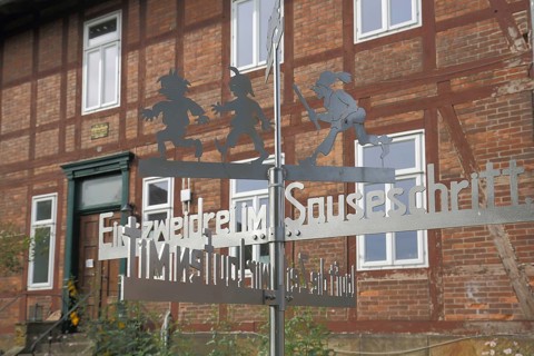 Max and Moritz with Schneider Böck in front of the Wilhelm bush House Museum with inscription one