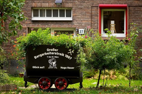 Coal lorry in the front garden commemorating the big miners' strike in 1997, Gelsenkirchen, Ruhr