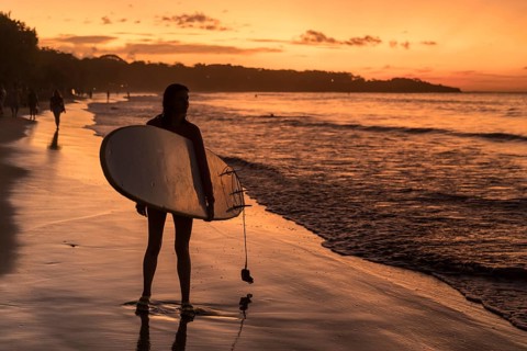 Surfers at sunset at Playa Tamarindo, Peninsula de Nicoya, Guanacaste, Costa Rica, Central America