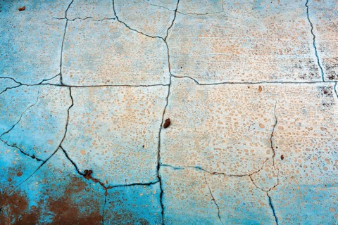 Dirty broken floor in a swimming pool, cracks, peeling paint, dilapidated swimming pool, lost