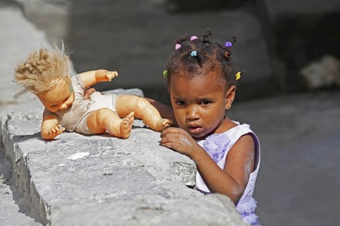 Creole girl with braided hair playing with doll on the island Santo Antão, Cape Verde, Cabo Verde,