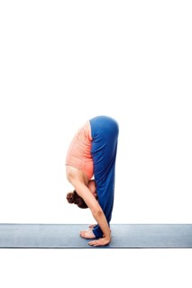 Woman doing Ashtanga Vinyasa Yoga Surya Namaskar Sun Salutation asana uttanasana, standing forward