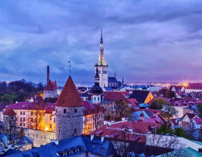 Aerial view of Tallinn Medieval Old Town with St. Olaf's Church and Tallinn City Wall illuminated
