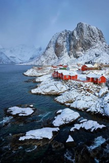 Iconic Hamnoy fishing village on Lofoten Islands, Norway with red rorbu houses. With falling snow
