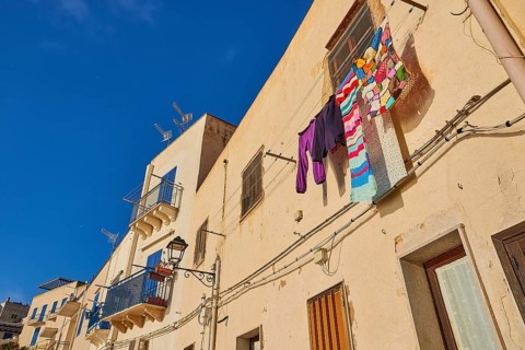 Morning light, row of houses, colourful houses, balconies, laundry on line, Levanzo town, main