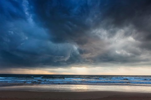 Gathering storm on beach with dark clouds. Baga, Goa, India, Asia