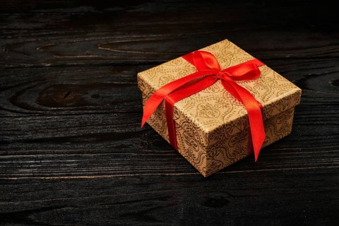 Gift birthday Christmas present concept, gift box with red ribbon on dark wooden background