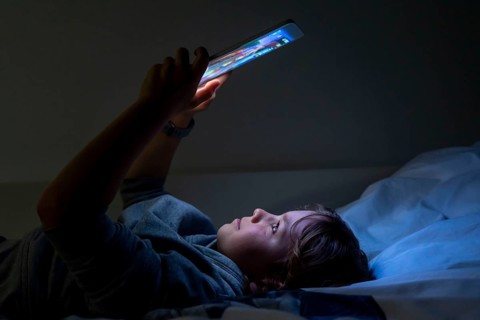 A boy plays computer games on a tablet PC