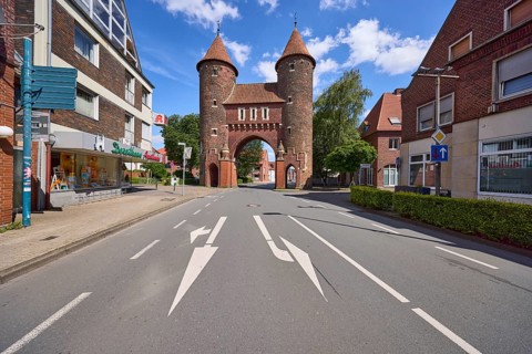 Historic city gate Lüdinghauser Tor against blue sky with cumulus clouds and Lüdinghauser Strasse
