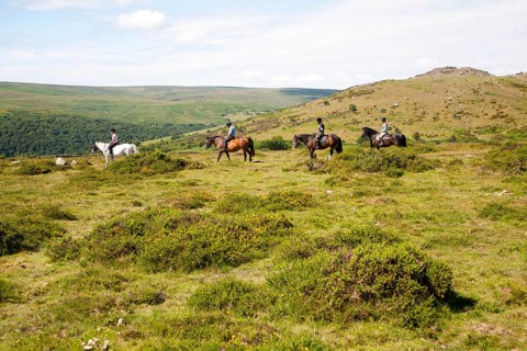 People riding horses by Sharp Tor, Dartmoor national park, Devon, England, UK