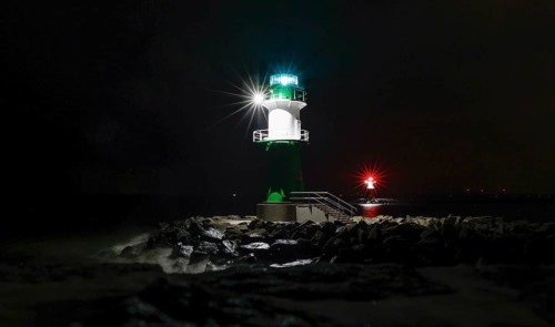 A lighthouse on the pier shows ships the way to Rostock harbour, Warnemünde, 09.02.2023