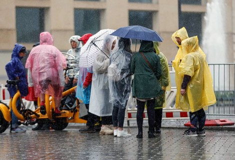 Tourists protect themselves from heavy rainfall with rain capes and umbrellas, Berlin, 23 06 2023