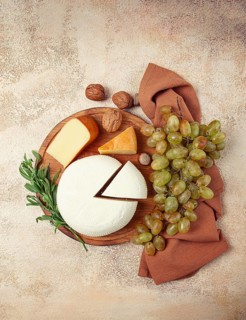 Georgian cheese, Imeretian and smoked suluguni, grapes, nuts, on a cutting board, Georgian cuisine,