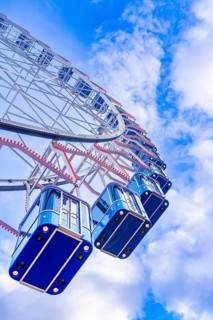 View upwards to a Ferris wheel in front of a clear blue sky, Stuttgart, Germany, Europe