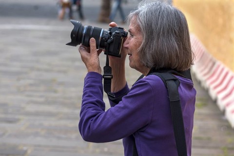 Tourist taking photos in the harbour of Genoa, Italy, Europe