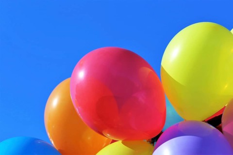 Close-up of colourful balloons against a blue sky