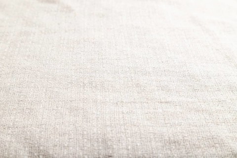 Fragment of smooth white linen tissue. Side view, natural textile background and texture