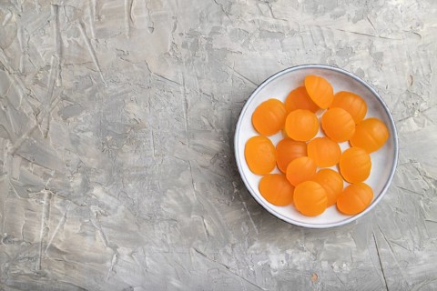 Jelly pumpkin candies on gray concrete background. copy space, top view, flat lay. autumn concept