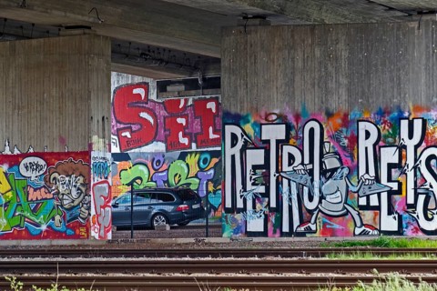 Colourful graffiti on a concrete wall in a subway with parked cars, Rhineland-Palatinate, Germany,