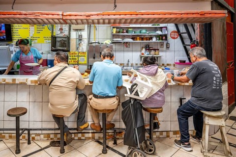 Visitors sitting at a food stall at the counter, Mercado Central de San José, San José, Costa Rica,