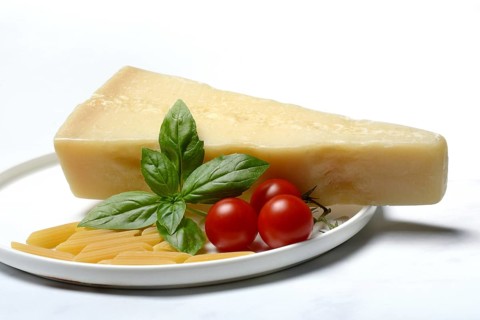 A piece of parmesan cheese with basil, pasta and tomatoes, Italy, Europe