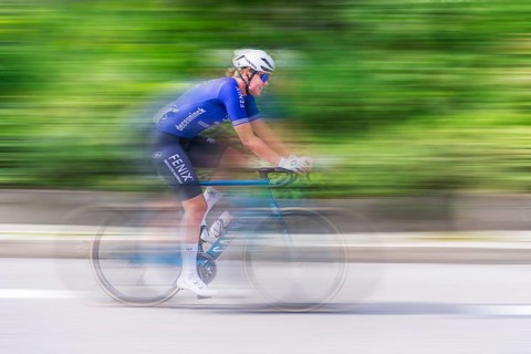 Cyclist in blue jersey riding fast on a road, movement and speed blur the image, race, Stuttgart,