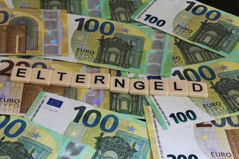 Symbolic image of parental allowance: Letters on euro notes show the word parental allowance
