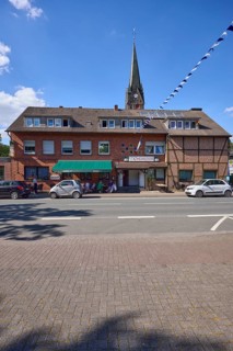 Weseler Strasse with building and church tower of St. Pankratius in the Buldern district, Dülmen,