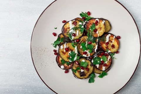 Fried eggplant, with white sauce, pomegranate seeds, top view, no people