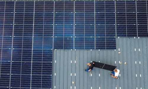Installation of solar modules on the roof of a barn on a farm, over 210 photovoltaic modules are