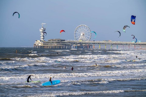 The pier and Ferris wheel at Scheveningen beach, strong swell, windsurfers, kitesurfers, surfers,