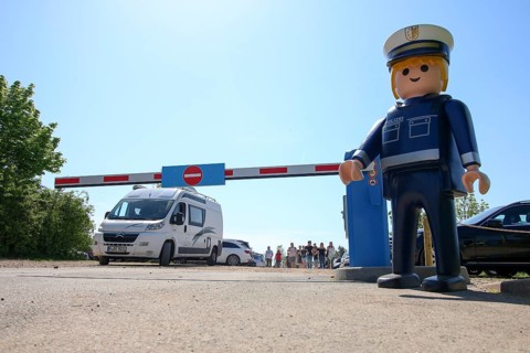 Playmobil-Firgur, behind it car park with barrier, Zirndorf, Bavaria, Germany, Europe