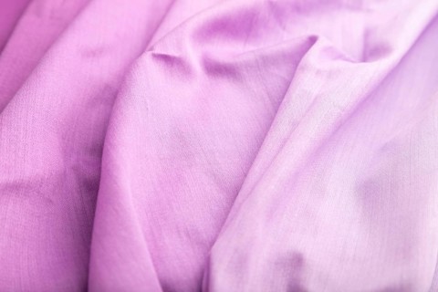 Fragment of cotton purple tissue. Side view, natural textile background and texture. wave concept,