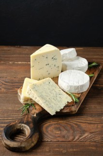 Wooden serving boar with different white cheeses