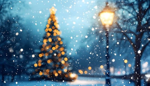 Christmas Eve with snowflakes fall under the light of a streetlamp with a decorated tree in the