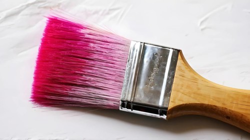 Thick paintbrush dipped in magenta bristles dripping onto a white background, AI generated